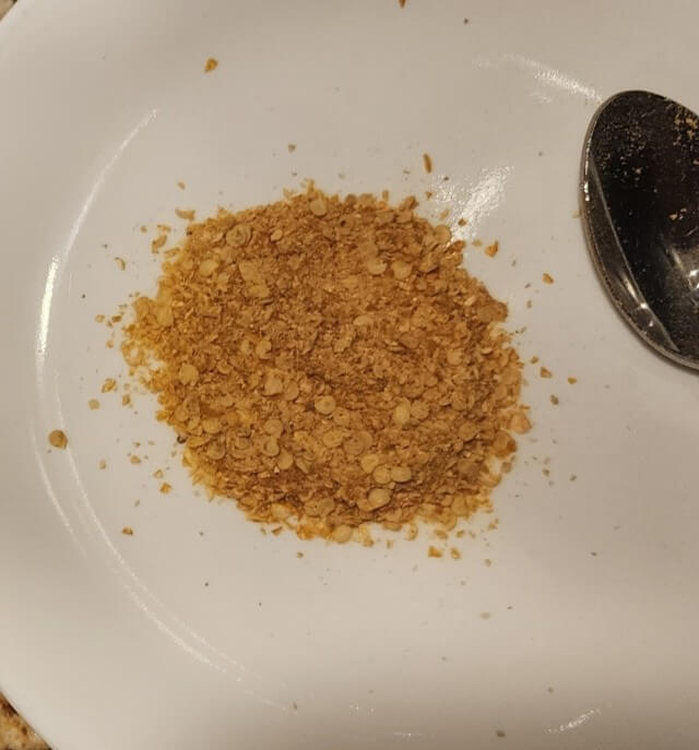 Coarse-ground dried hot peppers from a food processor on a plate.