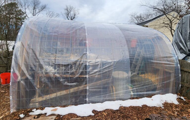Bunny barn covered with clear 6 mil plastic secured with grommets to create a greenhouse effect in winter