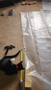 Installing metal grommets into clear plastic sheeting using hand tools for greenhouse enclosure